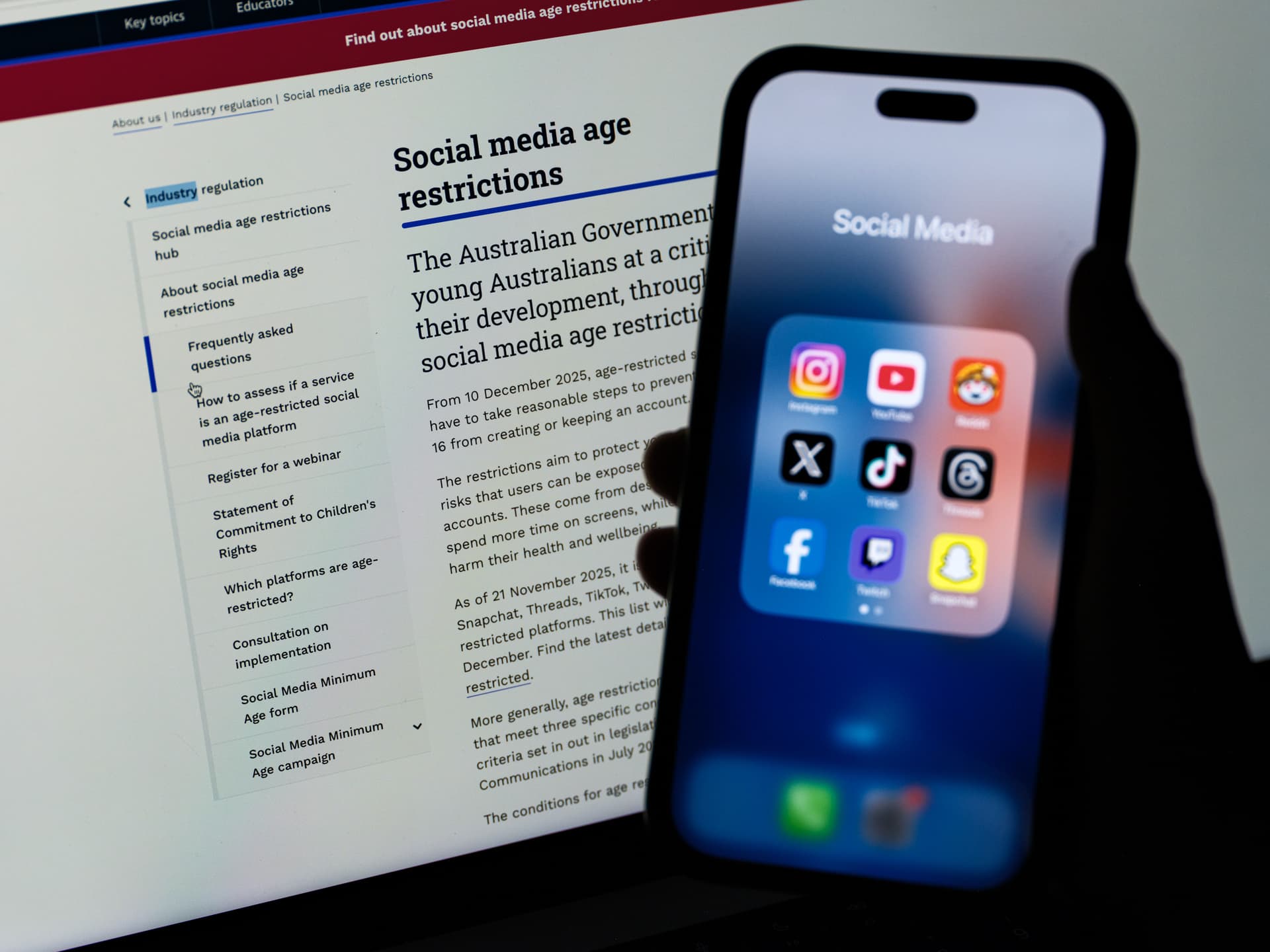 George Chan/Getty Images Social media networking apps are displayed on a phone with the eSafety Commissioner website displayed in the background at Sydney, Australia, on December 7, 2025.