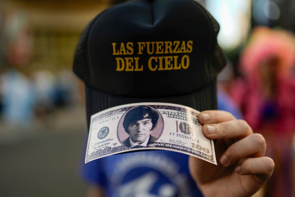 AP/Rodrigo Abd A supporter of Javier Milei holds a reproduction of a hundred dollar bill after polls closed in the presidential runoff election at Buenos Aires, November 19, 2023.