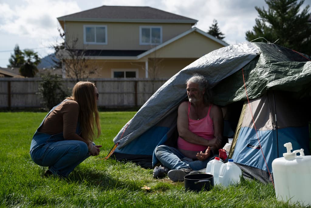 AP/Jenny Kane A nurse leads a group of volunteers working in a homeless encampment.