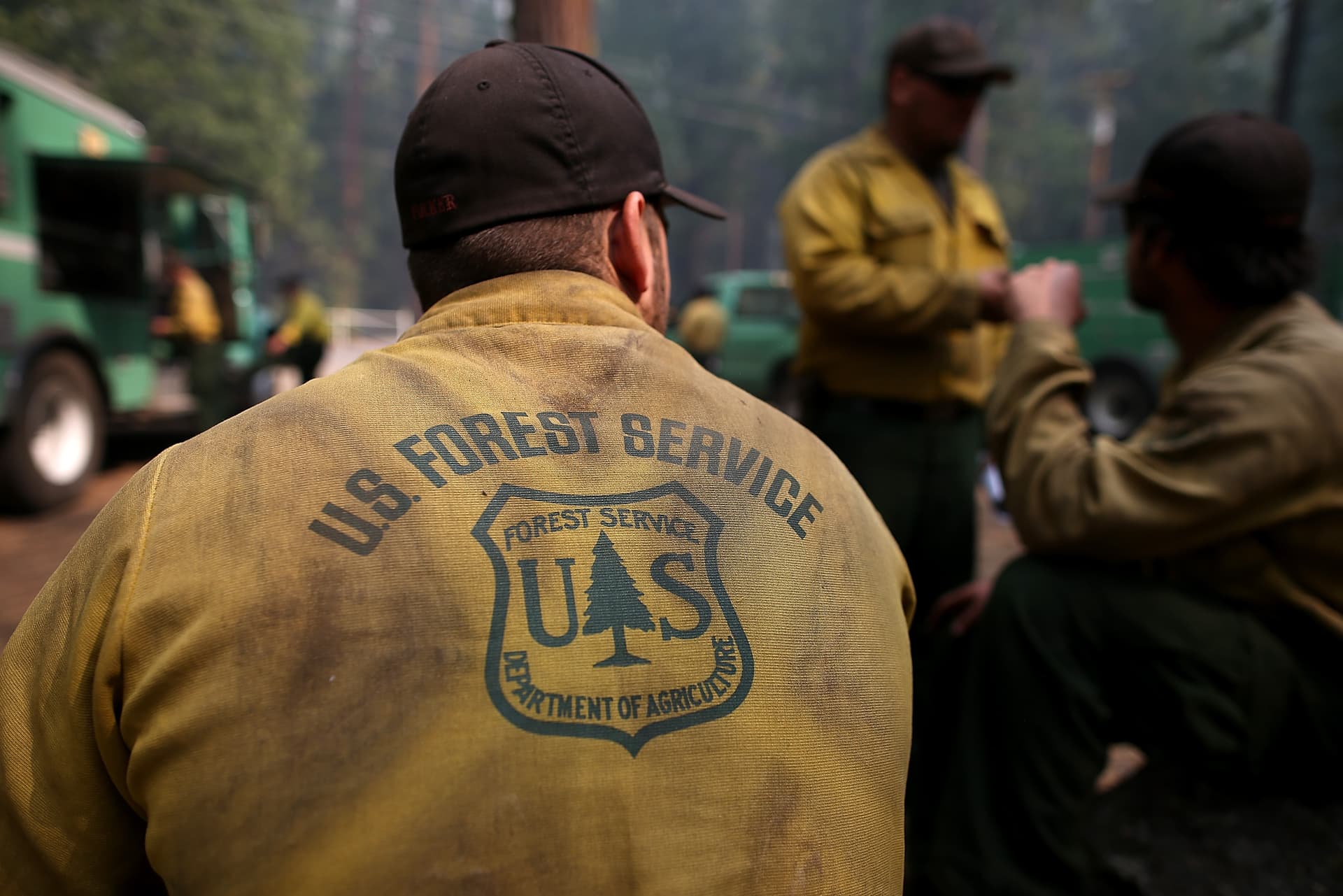 Justin Sullivan/Getty Images Forest Service firefighters take a break from battling a fire near Groveland, California.