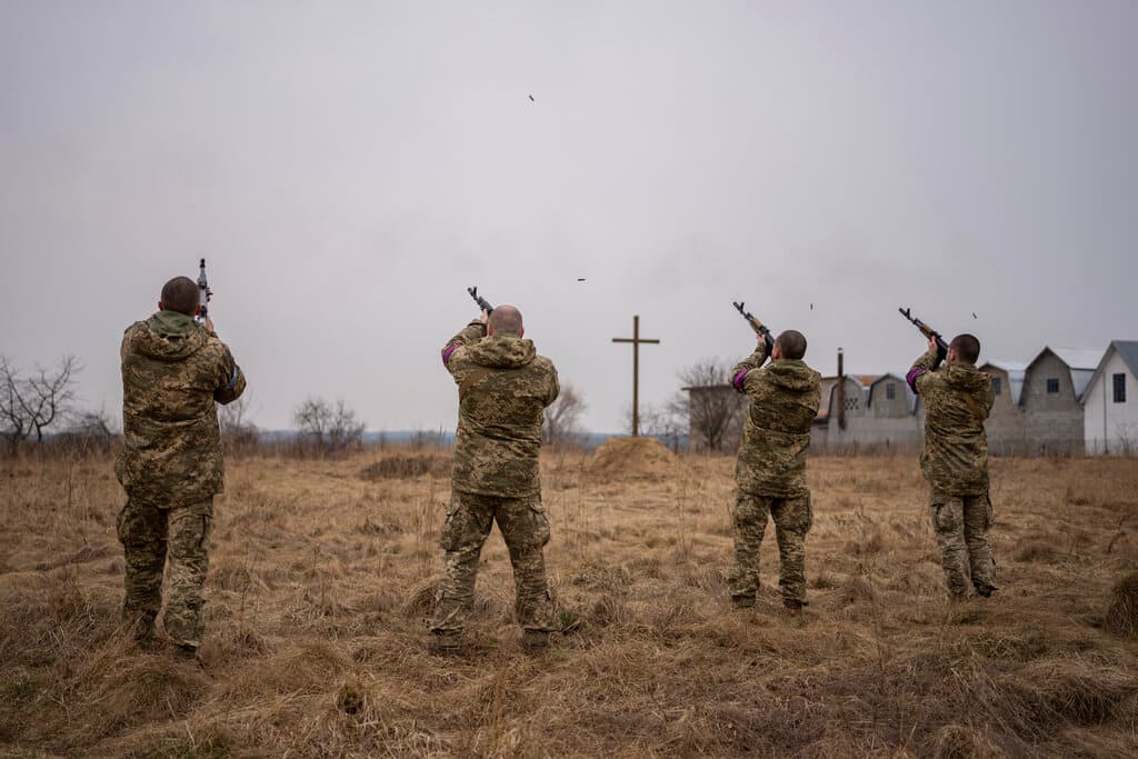 Ukrainian military servicemen fire salutes to fallen comrades during a funeral at Starychi, western Ukraine, March 16, 2022. AP/Bernat Armangue