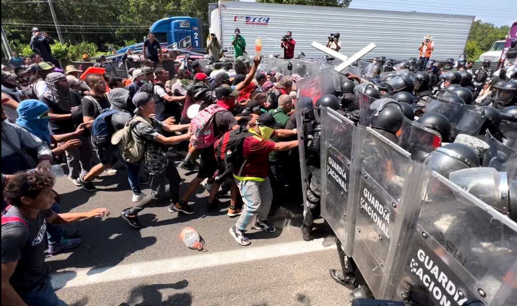 Migrants break through a line of National Guards at Tapachula, Mexico, Friday, April 1, 2022. AP Photo/Edgar H. Clemente