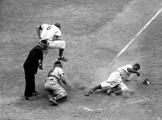 Jackie Robinson of the Brooklyn Dodgers steals home against the Boston Braves at Ebbets Field on September 28, 1948. AP