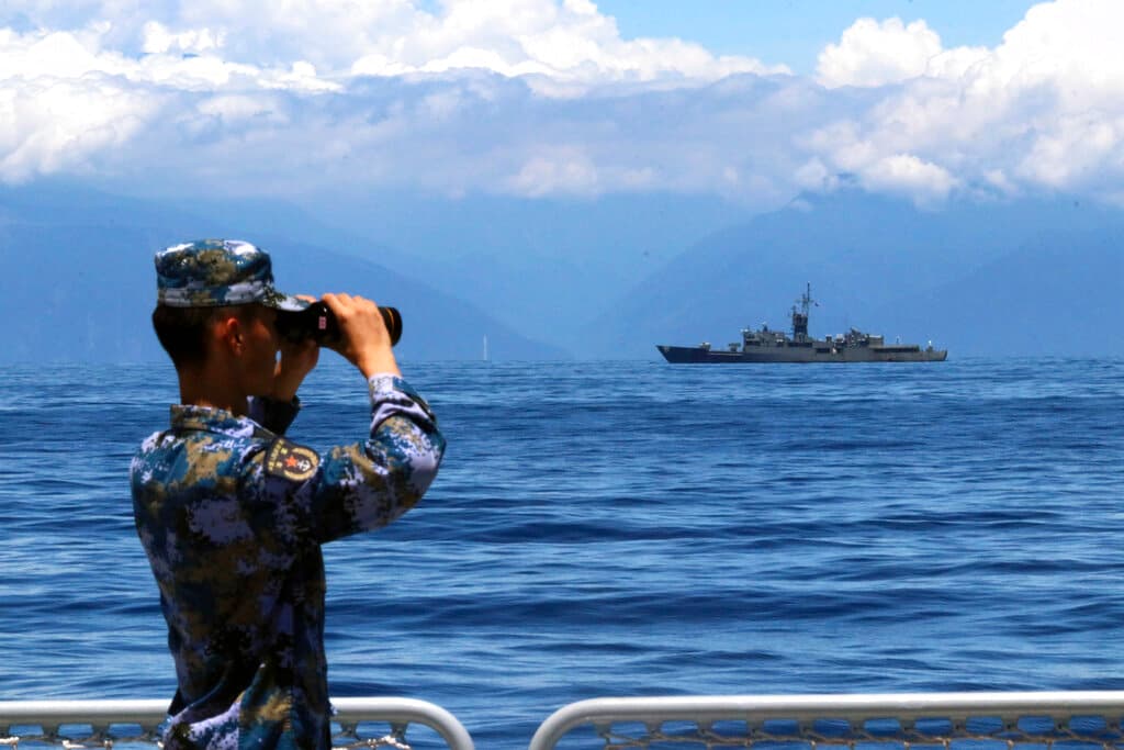 Lin Jian/Xinhua via AP A People's Liberation Army member during military exercises, with Taiwan’s frigate Lan Yang at the rear, August 5, 2022.