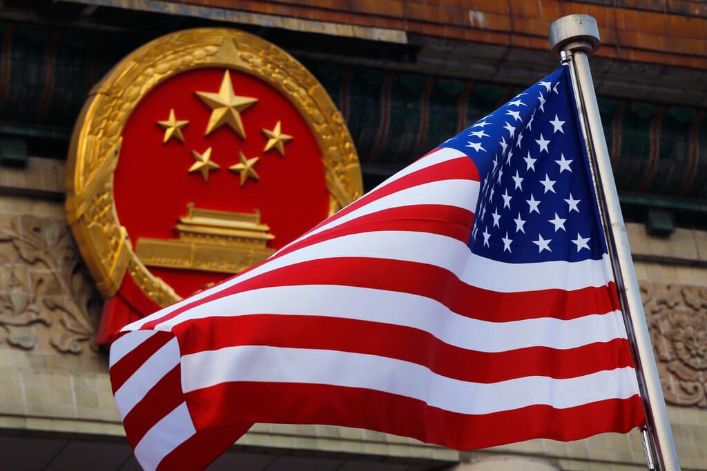AP/Andy Wong, file An American flag is flown next to the Chinese national emblem at the Great Hall of the People at Beijing, November 9, 2017.