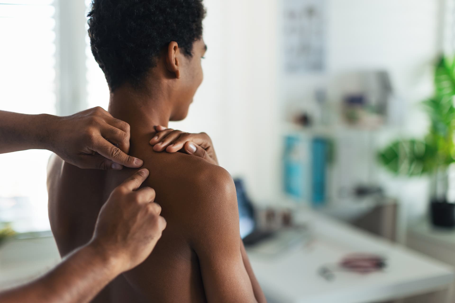 Getty Images A medical doctor examines acne on a teenager's back.