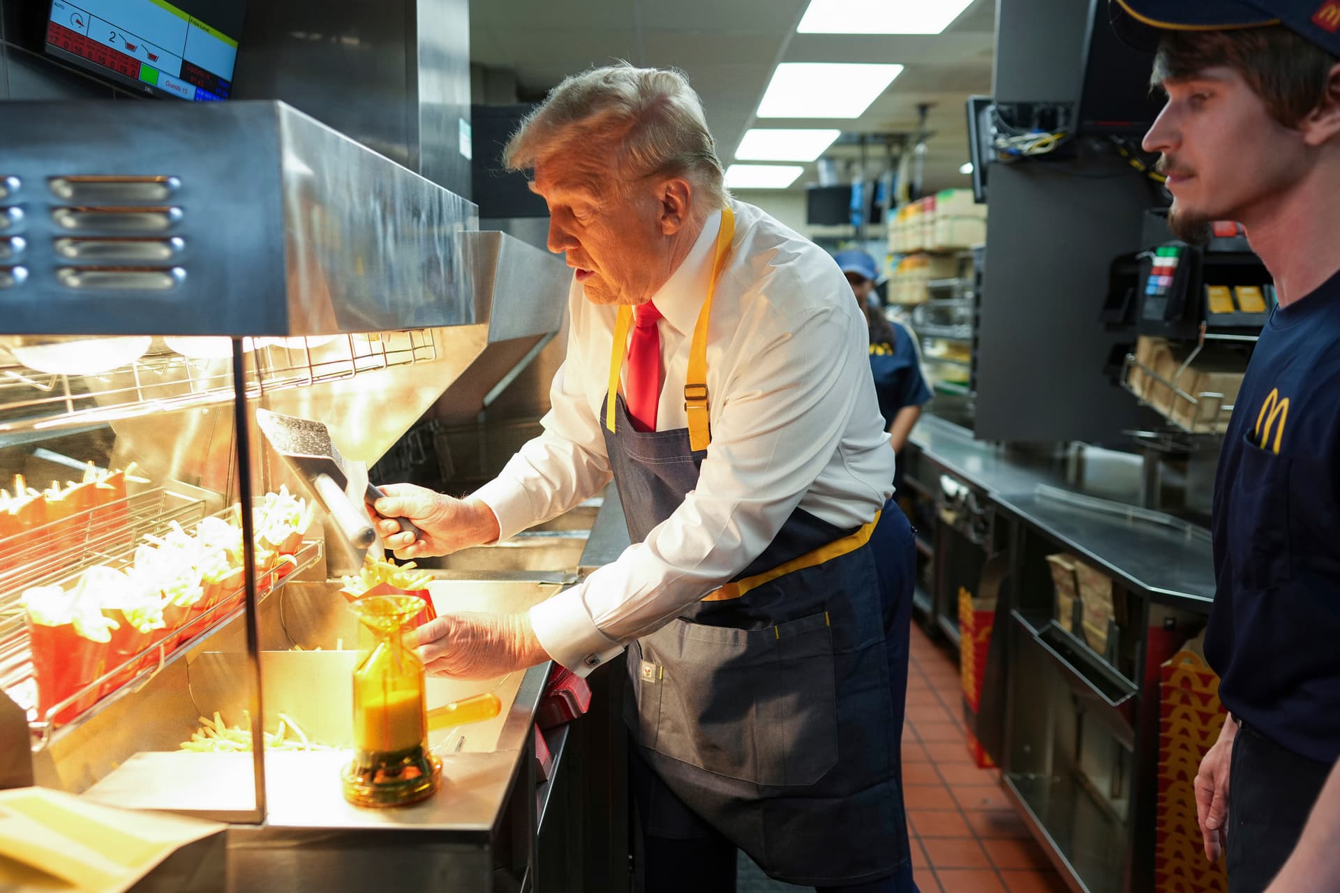 Doug Mills/The New York Times via AP President Trump serves french fries as an employee looks on during a visit to a McDonald's at Feasterville-Trevose, Pennsylvania, Sunday.