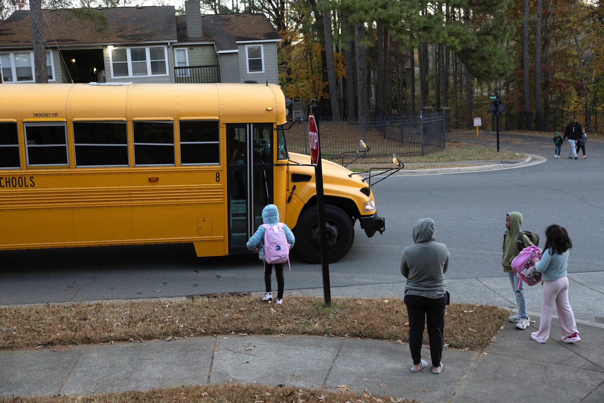 John Moore/Getty Images Students wait to board a school bus.