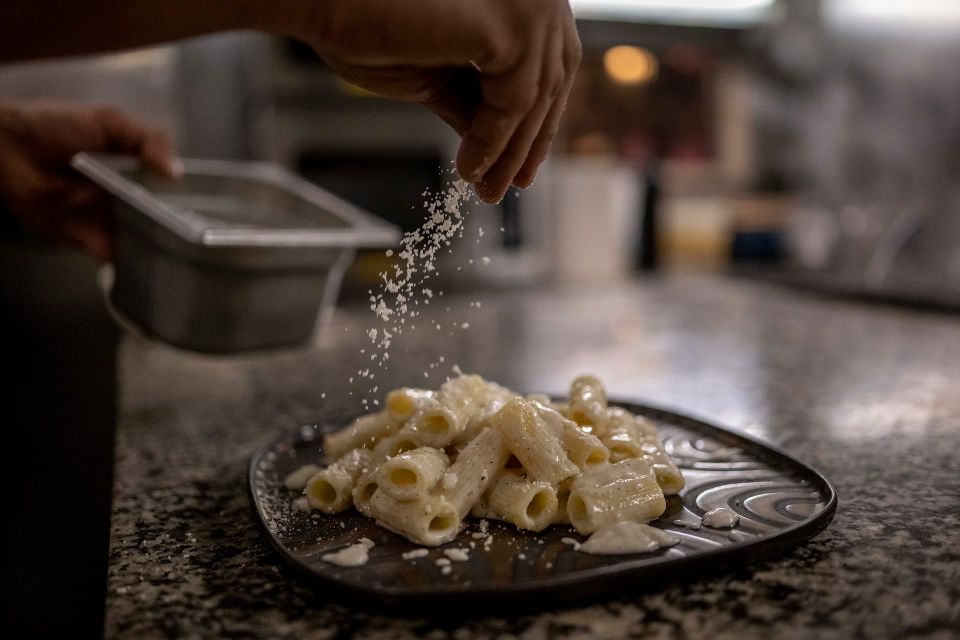 Antonio Masiello/Getty Images An Italian chef sprinkles Parmigiano cheese on the pasta "Gricia" at Saltimbocca restaurant at Rome on December 17, 2025.