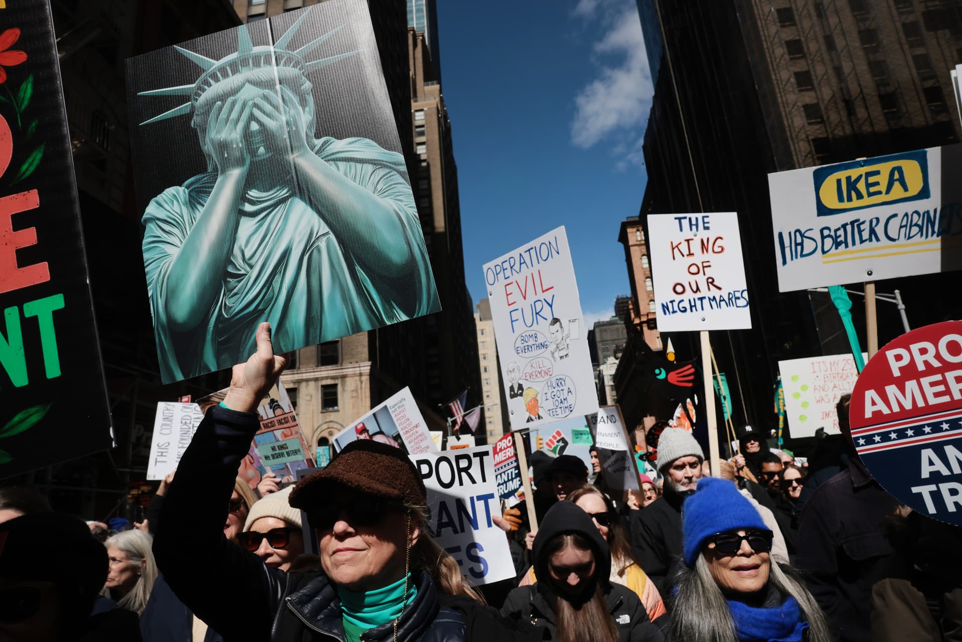 Spencer Platt/Getty Images Protesters hold signs as they participate in a 'No Kings' protest at New York City on March 28, 2026.