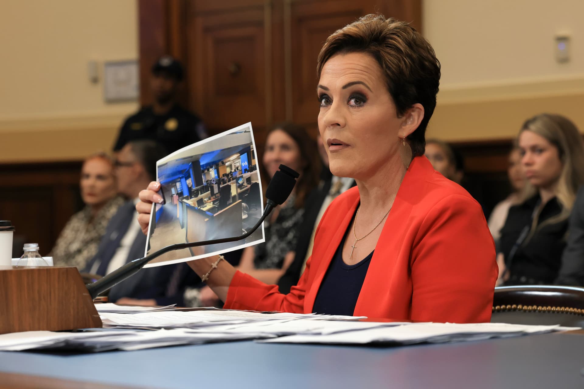 Joe Raedle/Getty Images Kari Lake displays a photograph of an empty Voice of America newsroom during testimony to a House Committee on Foreign Affairs hearing at Washington, D.C., on June 25, 2025