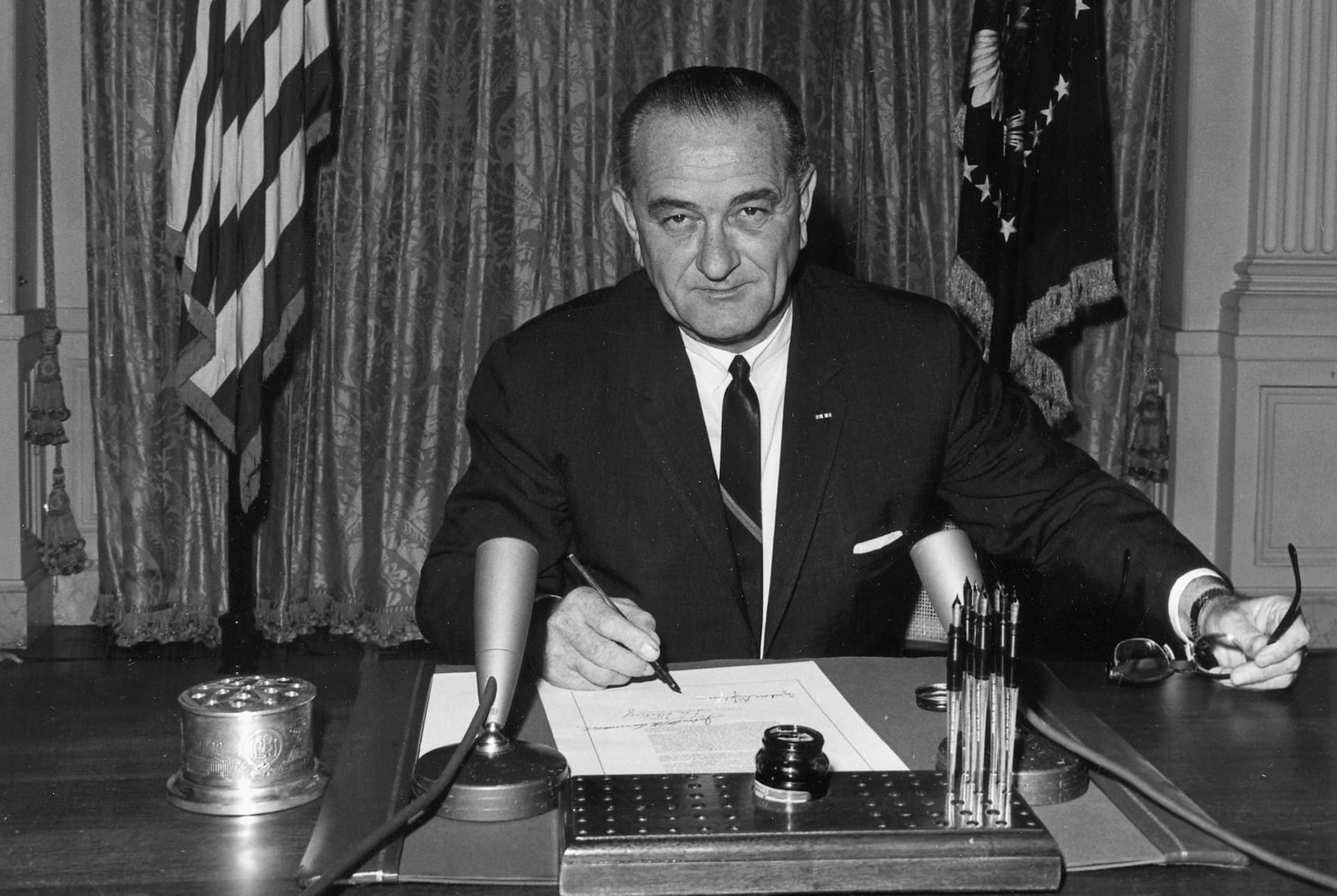 National Archives via Wikimedia Commons President Lyndon Johnson signs the Tonkin Gulf resolution at the White House, August 10, 1964.