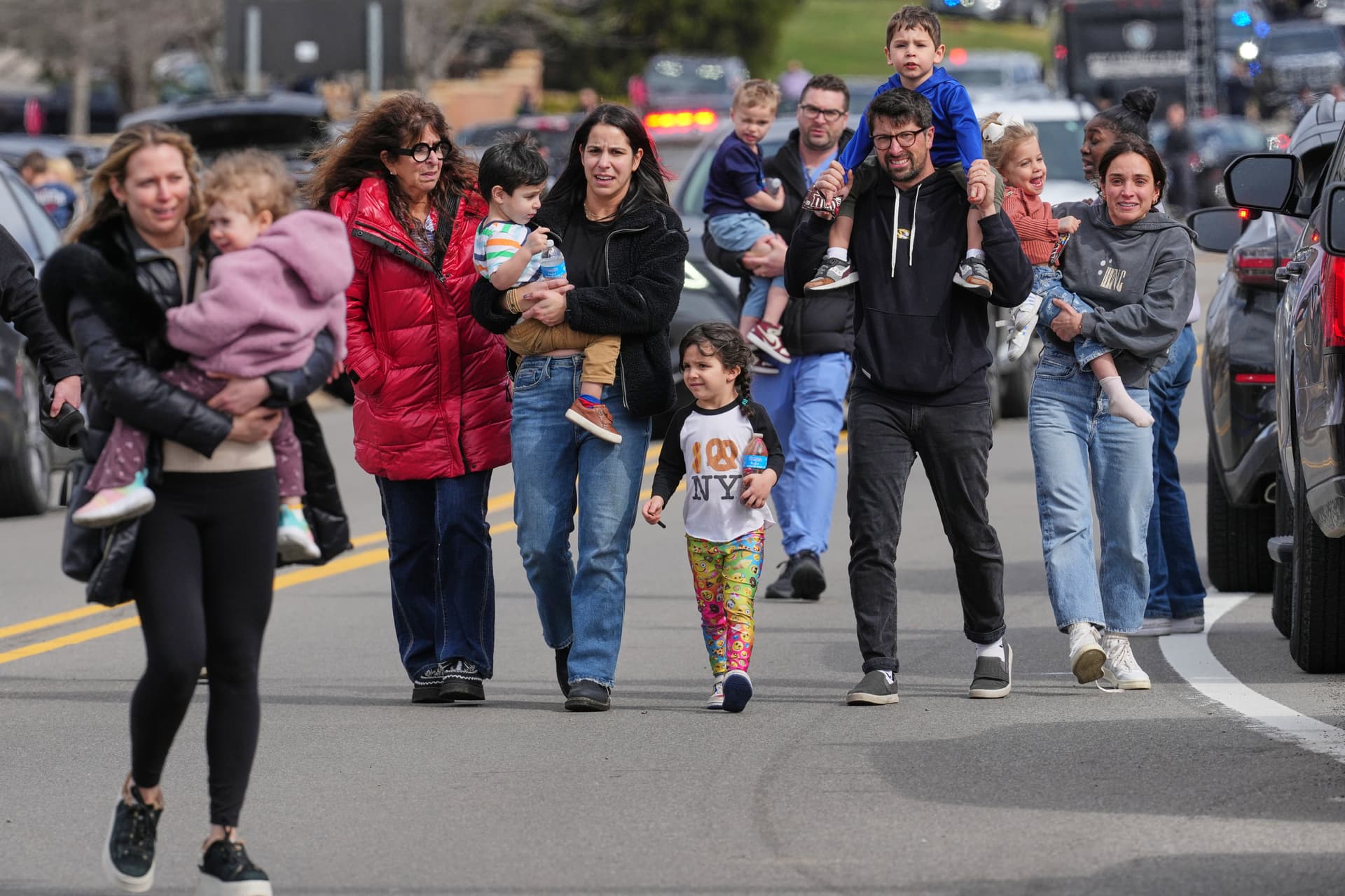 AP/Paul Sancya Law enforcement escort families with children away from the Temple Israel synagogue Thursday, March 12, 2026, at West Bloomfield Township, Michigan.