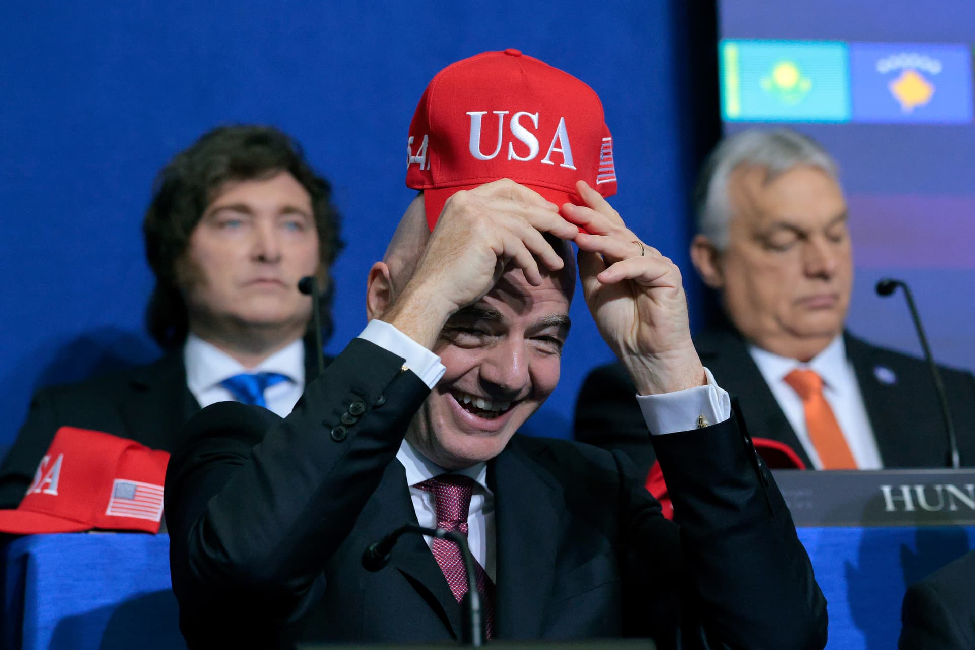 Chip Somodevilla/Getty Images The FIFA president, Gianni Infantino, holds up a USA hat as he attends the inaugural meeting of the Board of Peace at Washington, D.C., on February 19, 2026.