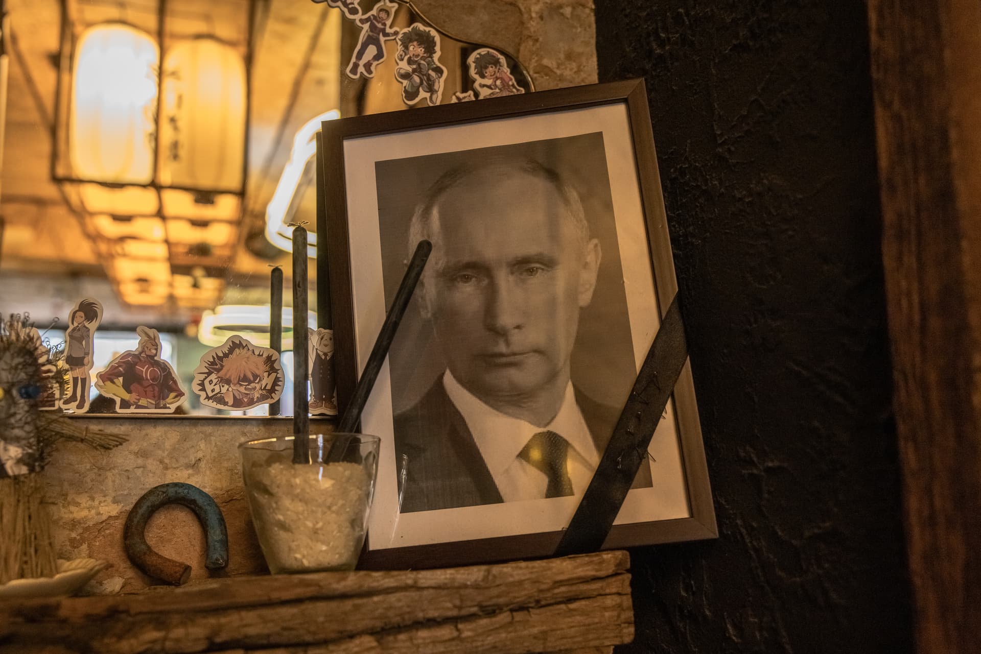 Getty Images A portrait of Russia's President Vladimir Putin, with a black ribbon over it commonly used for the deceased, is placed next to voodoo dolls, at a restaurant on March 18, 2023 in Kyiv, Ukraine.