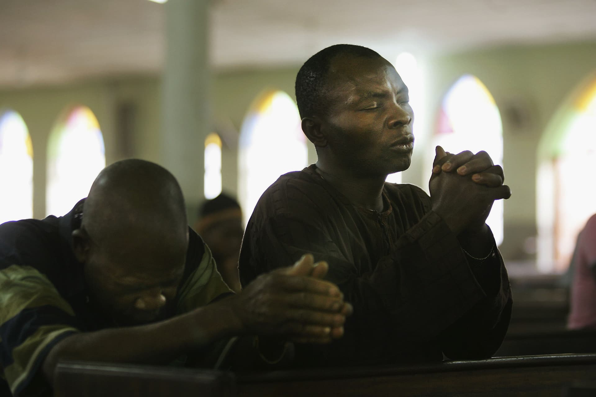 Photo by Chris Hondros/Getty Images FILE: Nigerian Catholic worshippers pray during morning mass at Kano, Nigeria.
