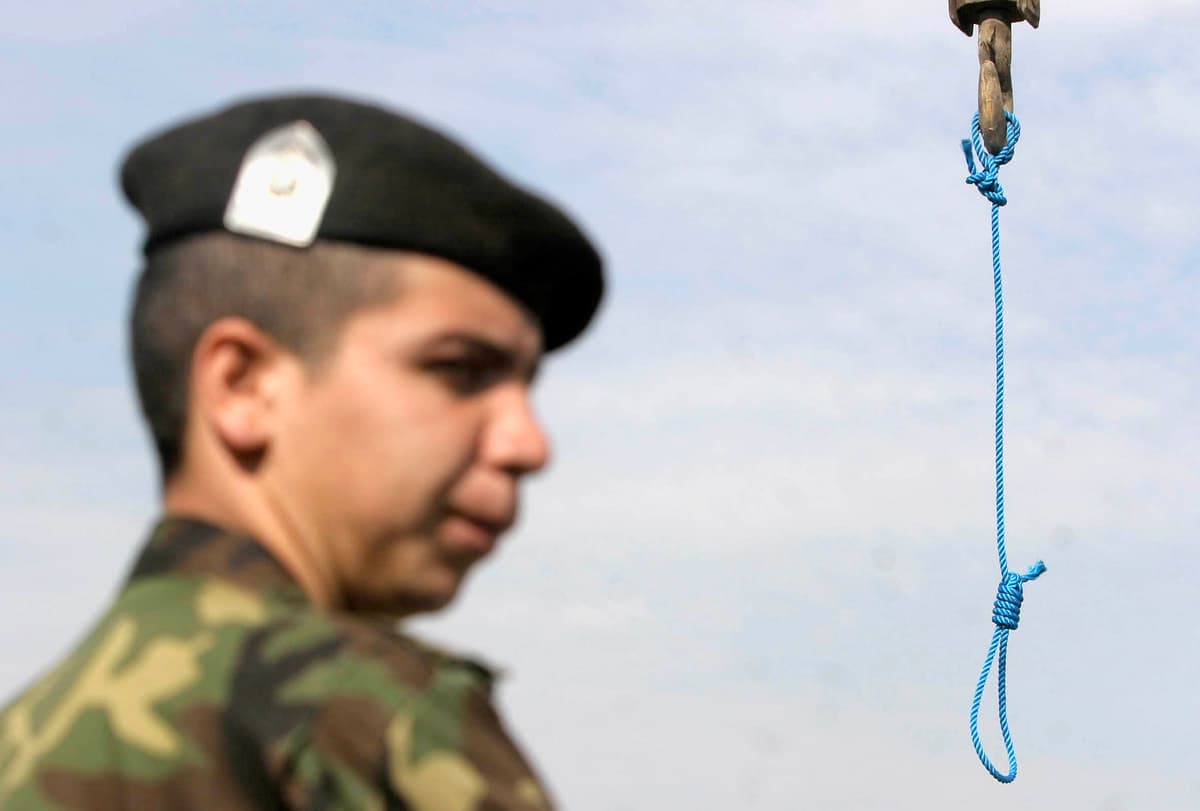 Getty Images An anti-riot police officer controls the area after a public hanging in Iran.
