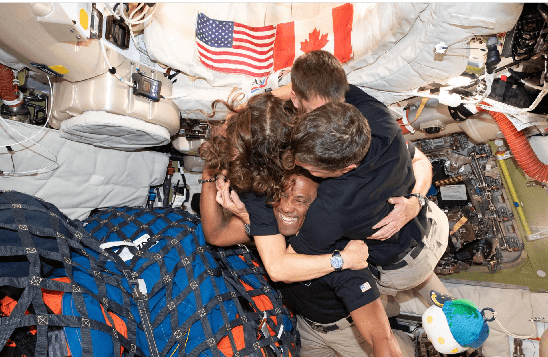 Via NASA The Artemis II crew — (clockwise from left) Mission Specialist Christina Koch, Mission Specialist Jeremy Hansen, Commander Reid Wiseman, and Pilot Victor Glover — take time out for a group hug inside the Orion spacecraft on their way home April 6, 2026.