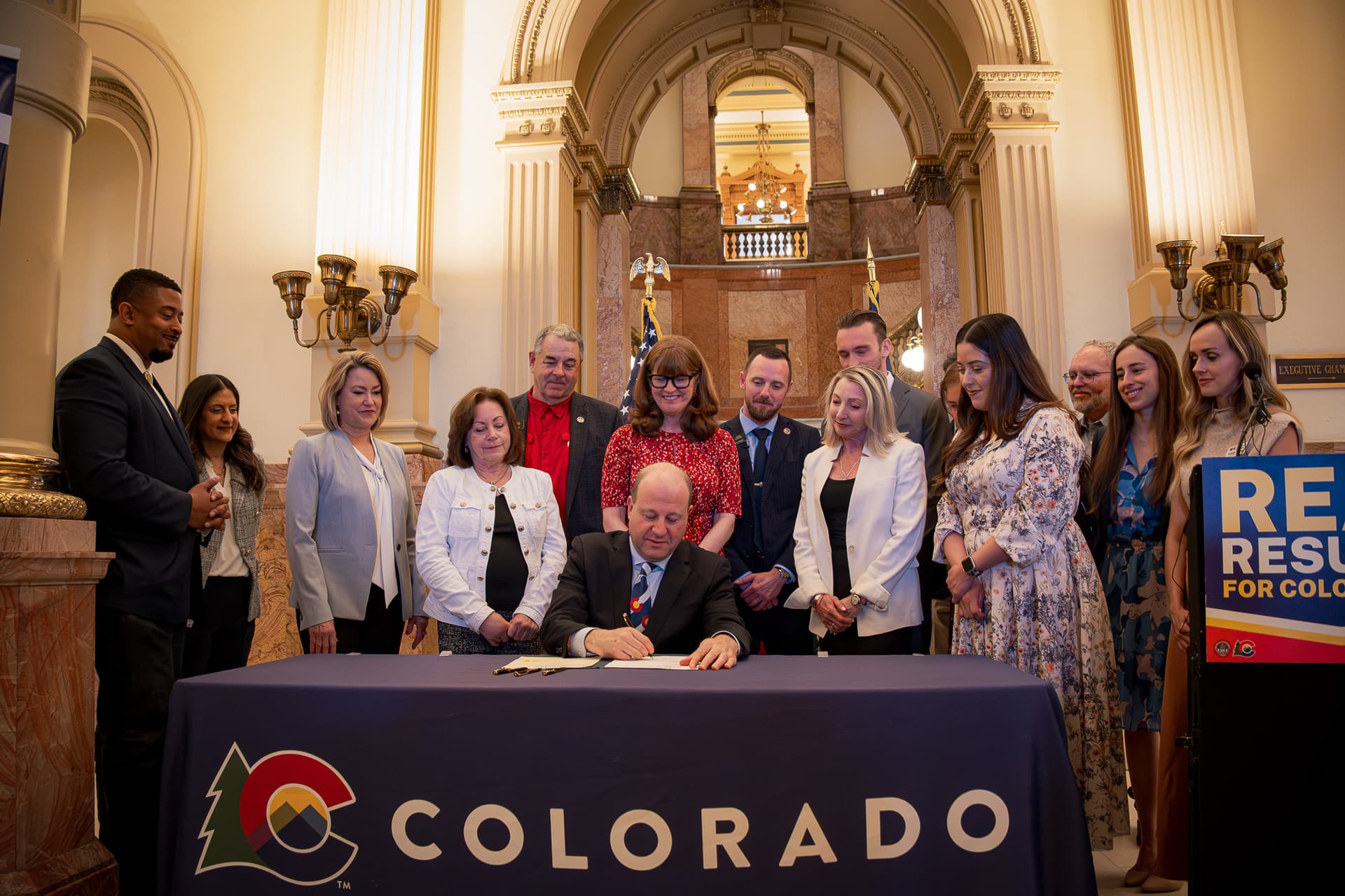 Jared Polis via Facebook Governor Jared Polis signs legislation at the statehouse at Denver on May 14, 2026.