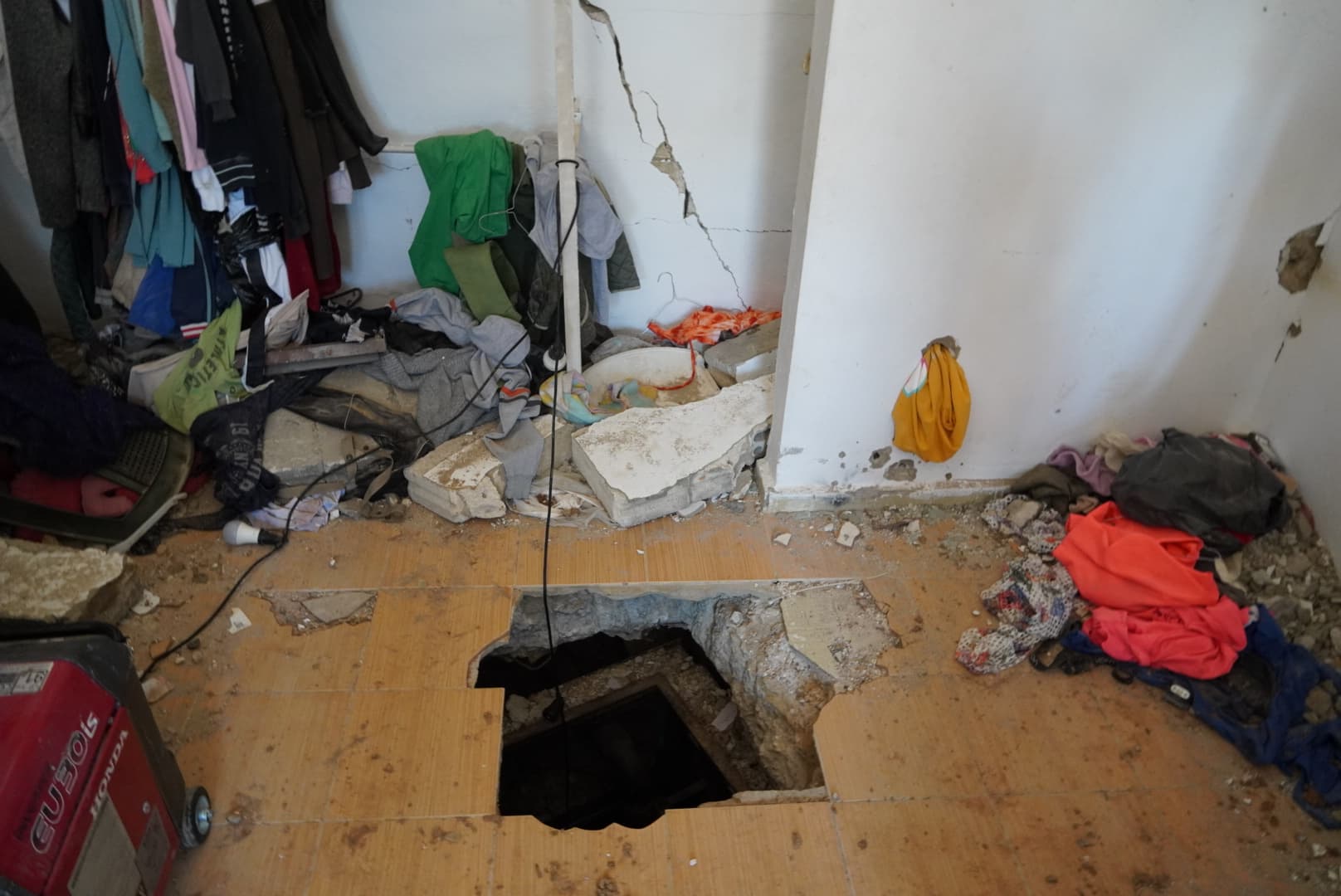 Jotam Confino/The New York Sun The opening in the floor is roughly the size of two floor tiles by two. To descend into the pitch-dark shaft, one climbs down a metal ladder to a small landing, where a spiral metal staircase continues deeper into the tunnel.