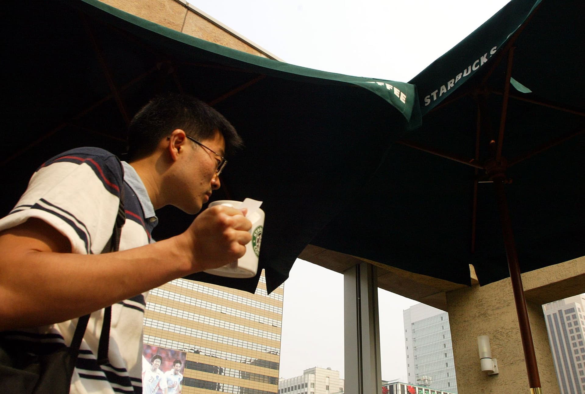 Chung Sung-Jun/Getty Images A customer drinks a beverage from Starbucks coffee store in Seoul, South Korea.