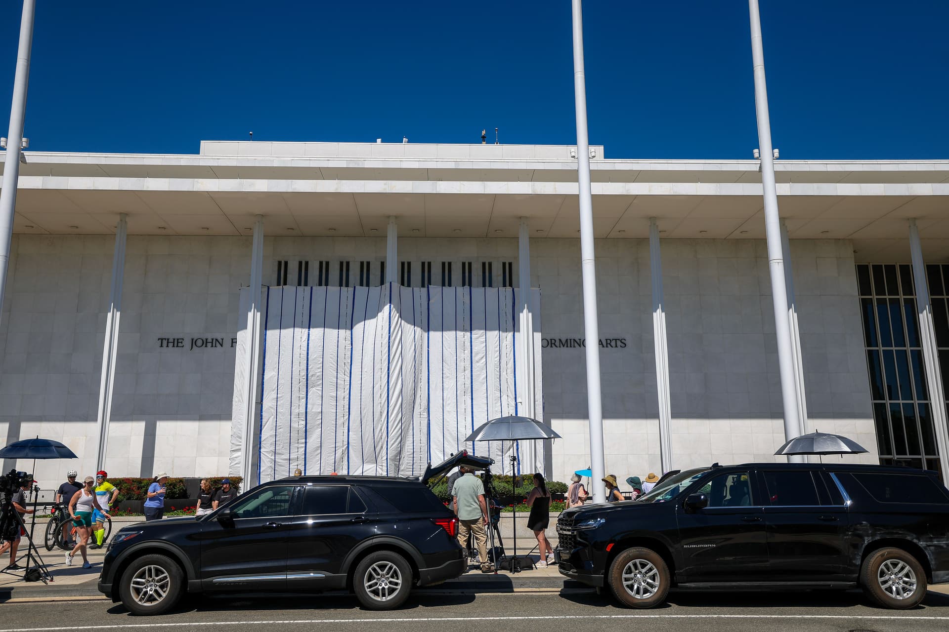 Tasos Katopodis/Getty Images Sight-seers and media gather as tarps are hung on scaffolding outside The Kennedy Center at Washington, D.C., on June 13, 2026.