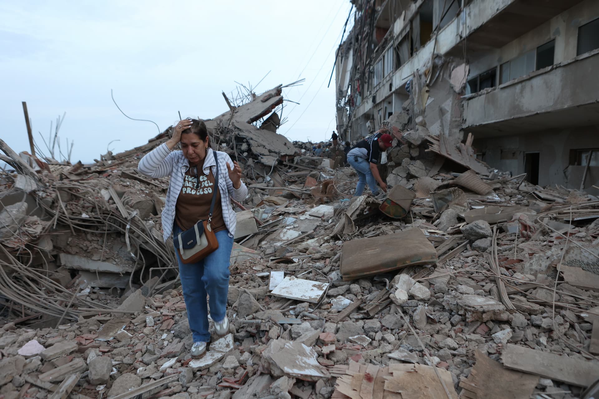 Pedro Mattey/AP A woman walks through the rubble of buildings damaged by this week’s twin earthquakes at Catia La Mar, Venezuela, on June 25, 2026.