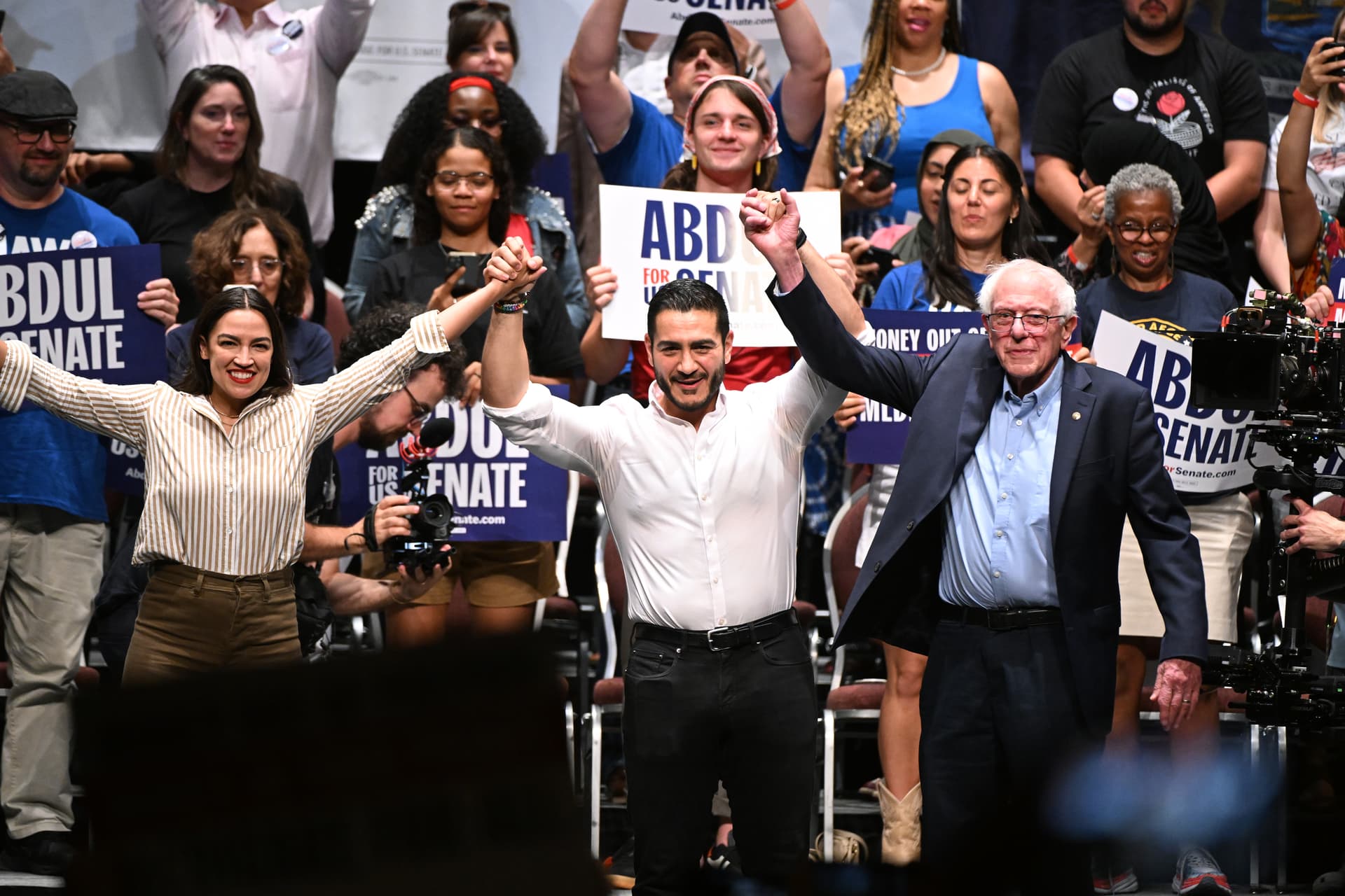 AP/Jose Juarez Congresswoman Alexandria Ocasio-Cortez, Michigan Democratic U.S. Senate primary candidate Abdul El-Sayed, and Senator Bernie Sanders join hands together following a campaign rally, July 18, 2026, at Detroit.