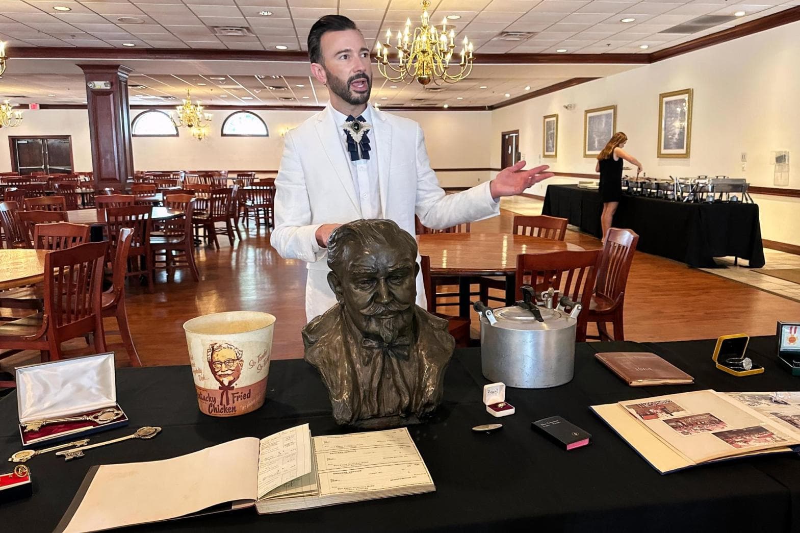 AP/Dylan Lovan Auctioneer Jonathan Klunk surrounded by items owned by Colonel Sanders on July 22, 2026, in Shelbyville, Kentucky.
