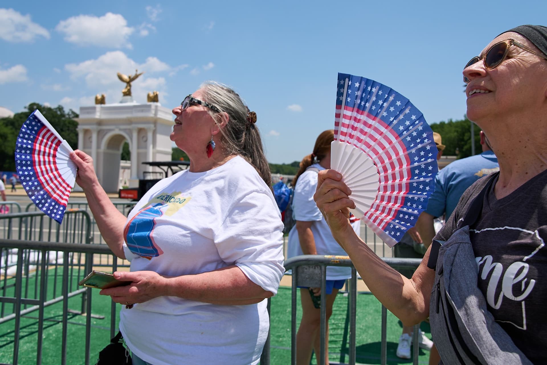 Jacquelyn Martin/AP Visitors fan themselves while waiting in line for the ferris wheel at the Great American State Fair at Washington, D.C, on July 1, 2026.