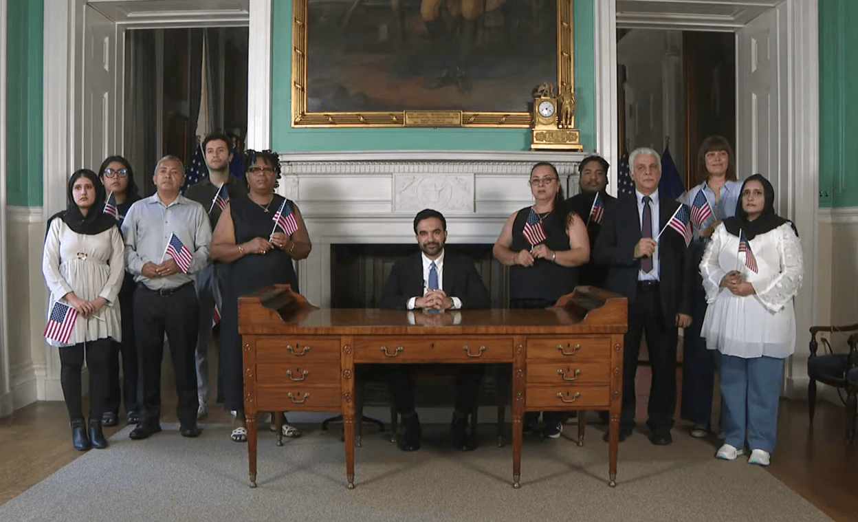 Via YouTube Mayor Zohran Mamdani, seated at George Washington's desk and surrounded by new citizens, delivers his Independence Day Eve speech.