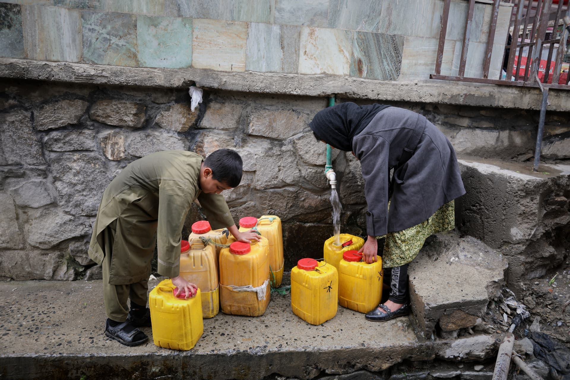 Siddiqullah Alizai/AP A boy and a girl collect water from a hose connected to a well at a mosque at Kabul, Afghanistan, on April 2, 2026.