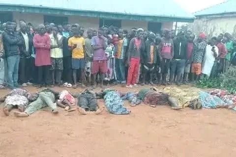Catholic Diocese of Kafanchan via X Community members stand behind the bodies of victims of a massacre at the village of Naridon in Nigeria ahead of a mass burial on August 1, 2026.
