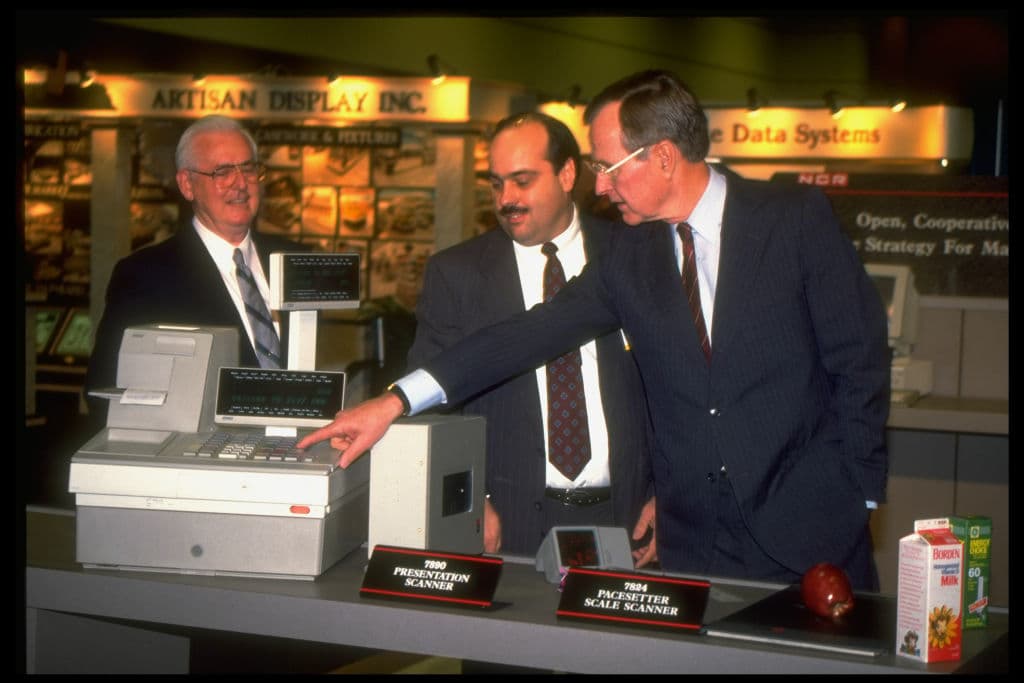 Dirck Halstead/Getty Images President Bush (R) inspecting supermarket checkout-counter technology at the National Grocers Association convention.