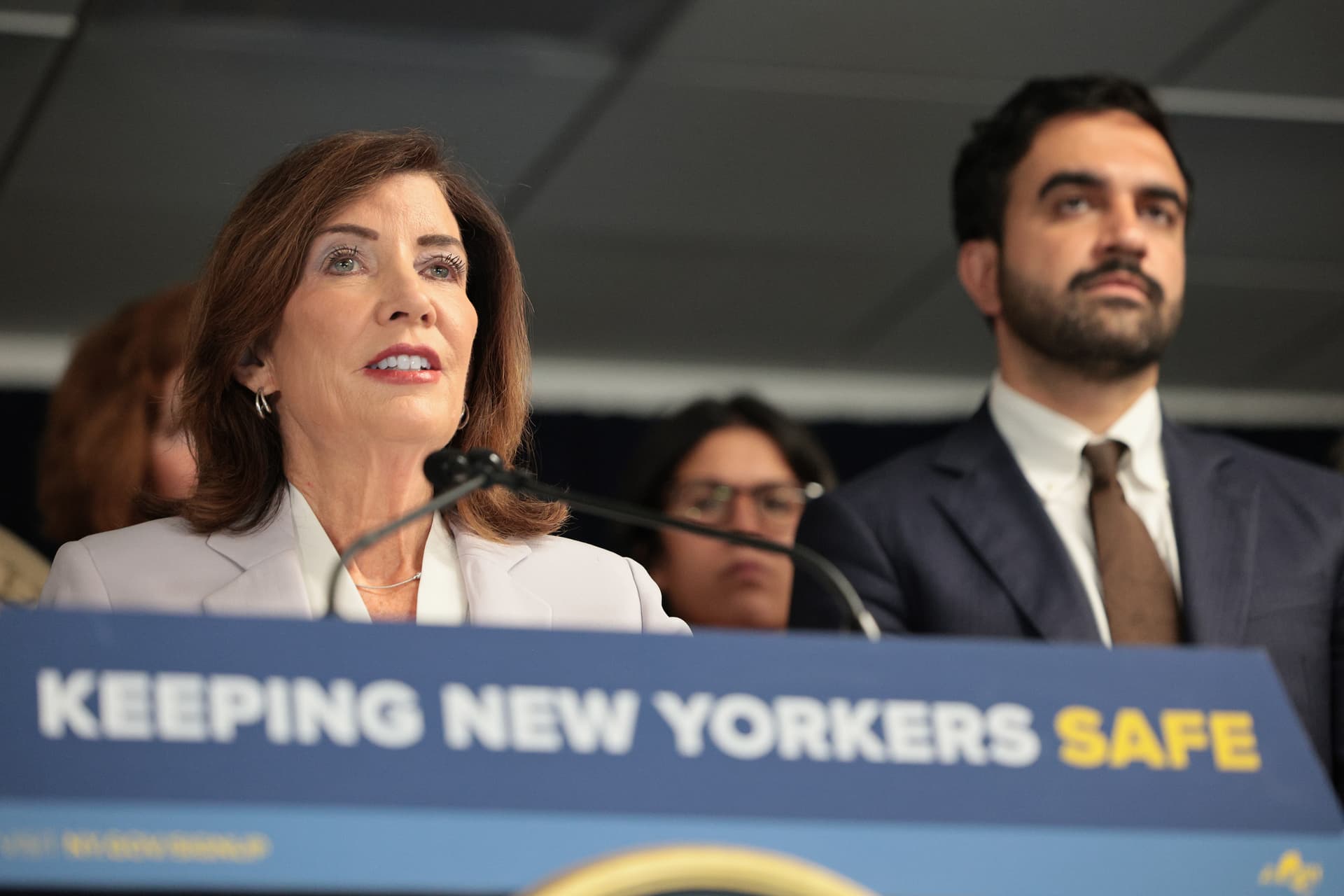 Michael M. Santiago/Getty Images. New York Gov. Kathy Hochul speaks as New York City Mayor Zohran Mamdani listens during a press conference.