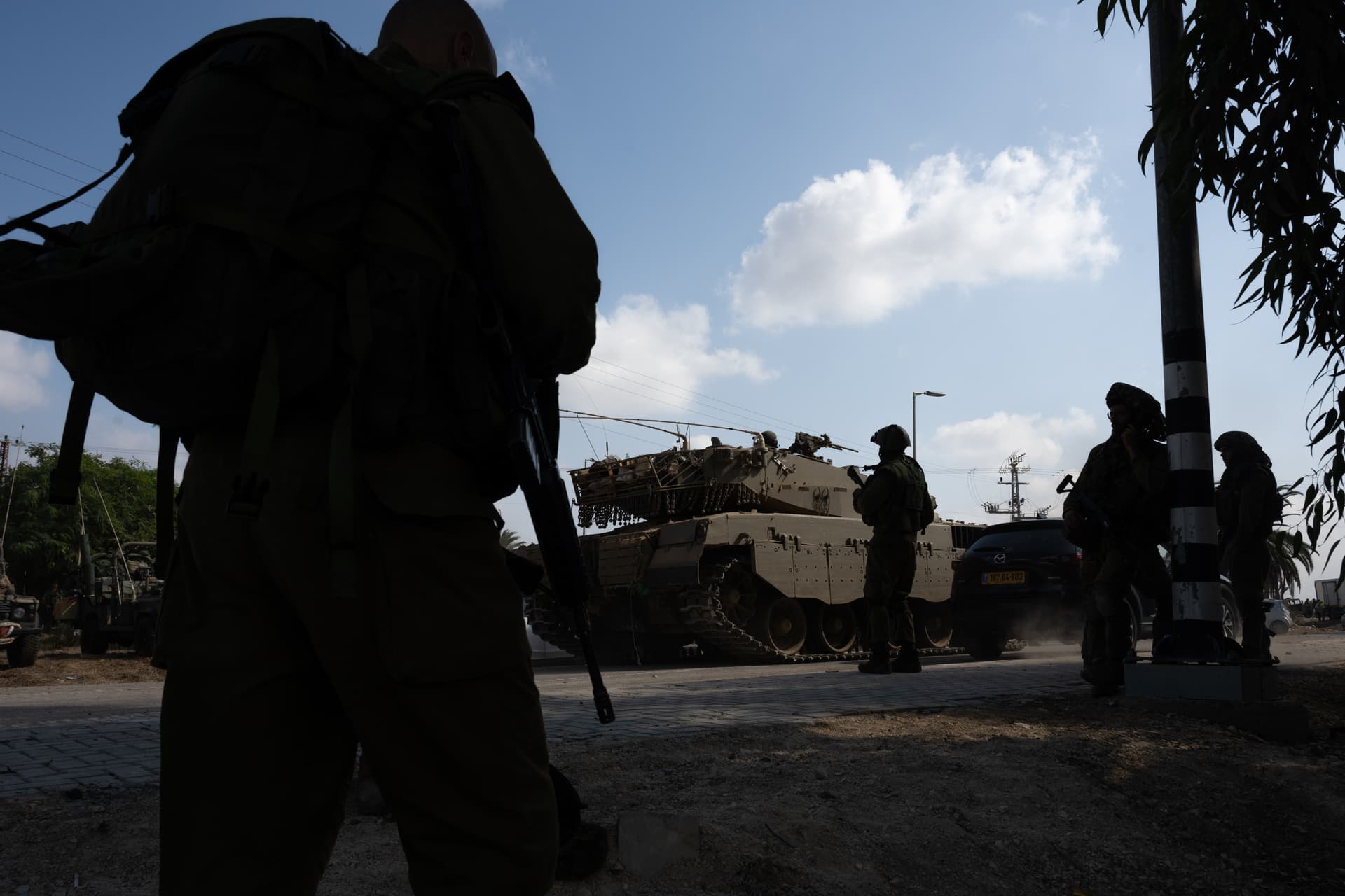 Alexi J. Rosenfeld/Getty Images Soldiers walk past tanks on October 10, 2023, outside of Kibbutz Kfar Aza where three days earlier Hamas terrorists had killed 62 to 64 residents.